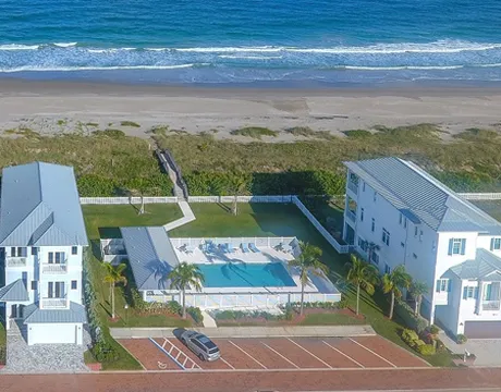Aerial view of two homes and pool on beach